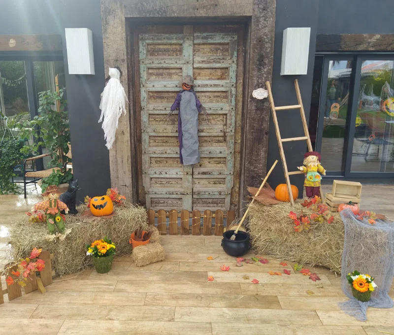 Entrada decorada com fantasma, caldeirão e abóboras